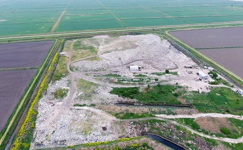 garbage dump with heaps of garbage and treatment facilities. Landfill of garbage outside the village